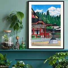 Red Temple by Hasui Kawase, Japanese woodblock print black framed on a living room shelf