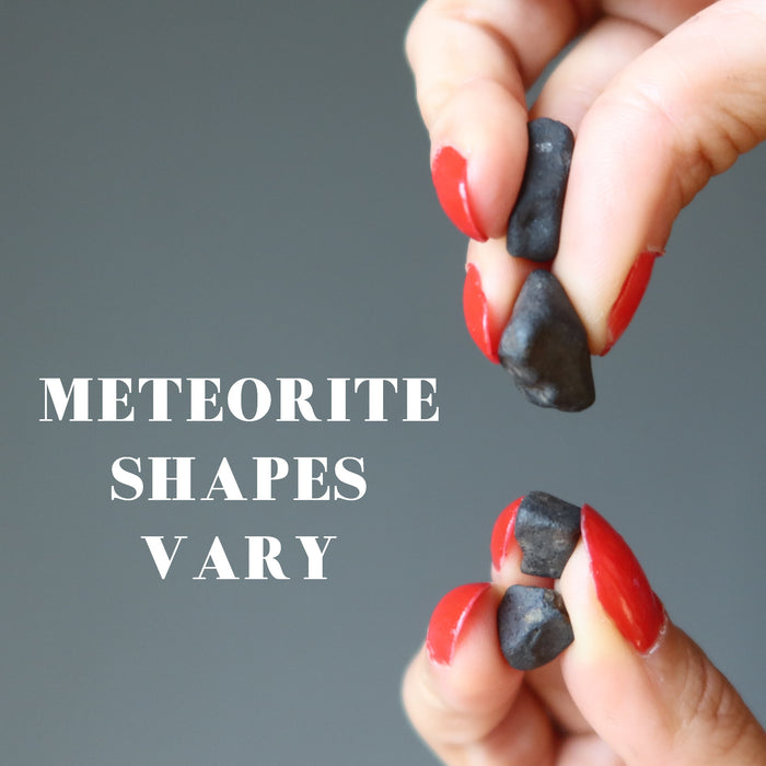 hand holding two chelyabinsk meteorite sets to show meteorite shapes vary