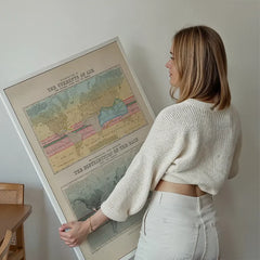 Currents of air and distribution of rain art print held up against a living room wall