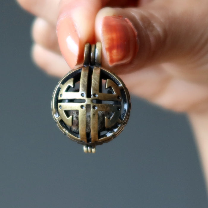 hand holding gao-guenie meteorite pendant