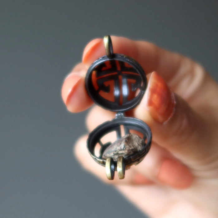 hand holding gao-guenie meteorite pendant