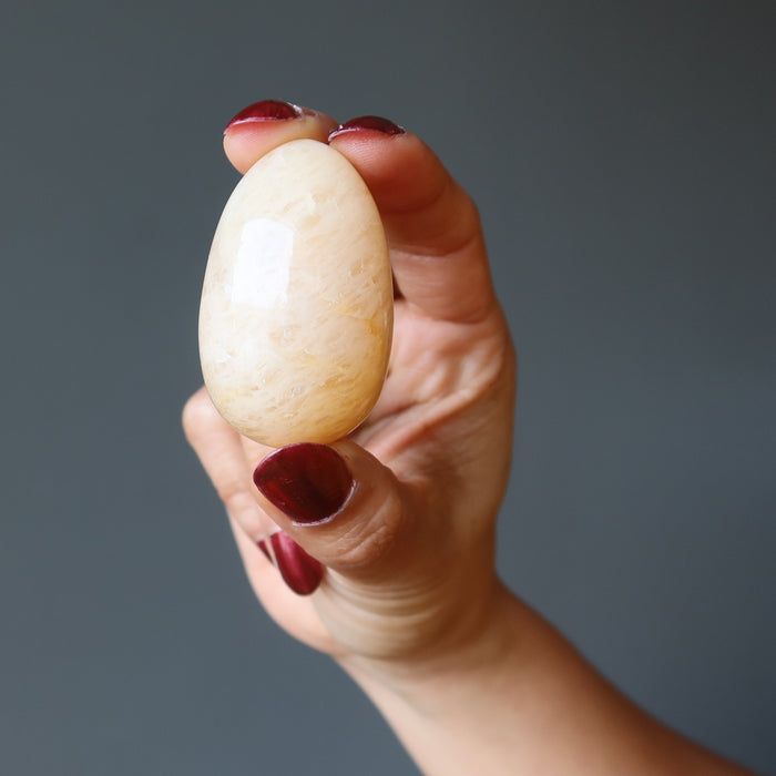 hand holding yellow aventurine egg