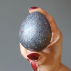 hand holding hematite egg
