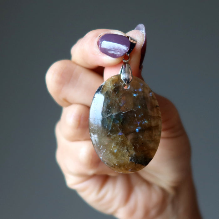 hand holding oval labradorite pendant