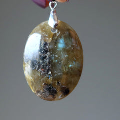 hand holding oval labradorite pendant