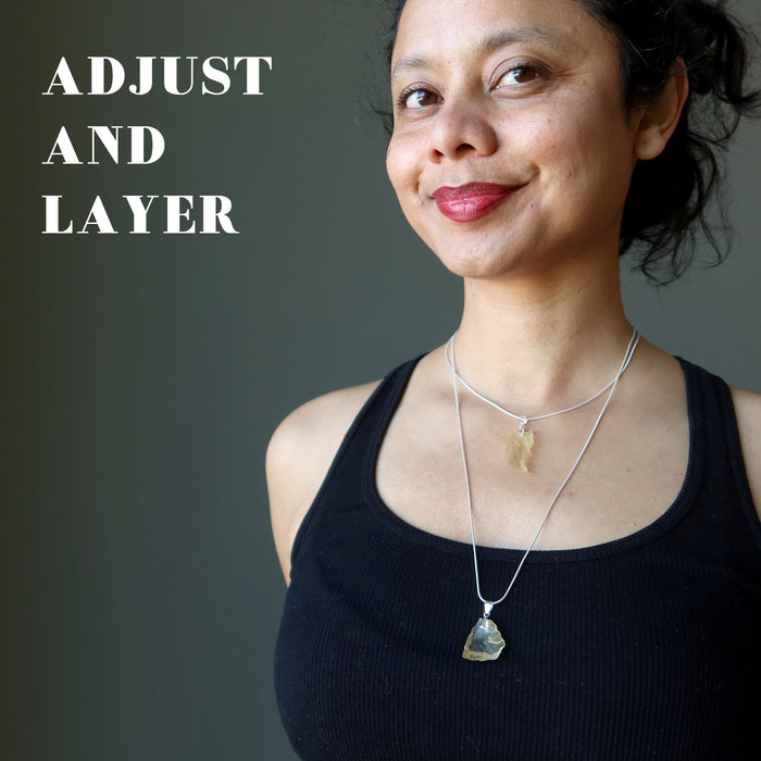 female wearing raw yellow libyan desert glass tektite on sterling silver adjustable necklaces to show you can adjust and layer