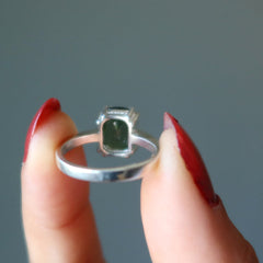 hand holding moldavite ring showing back