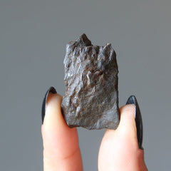 hand holding brown rocky nantan meteorite