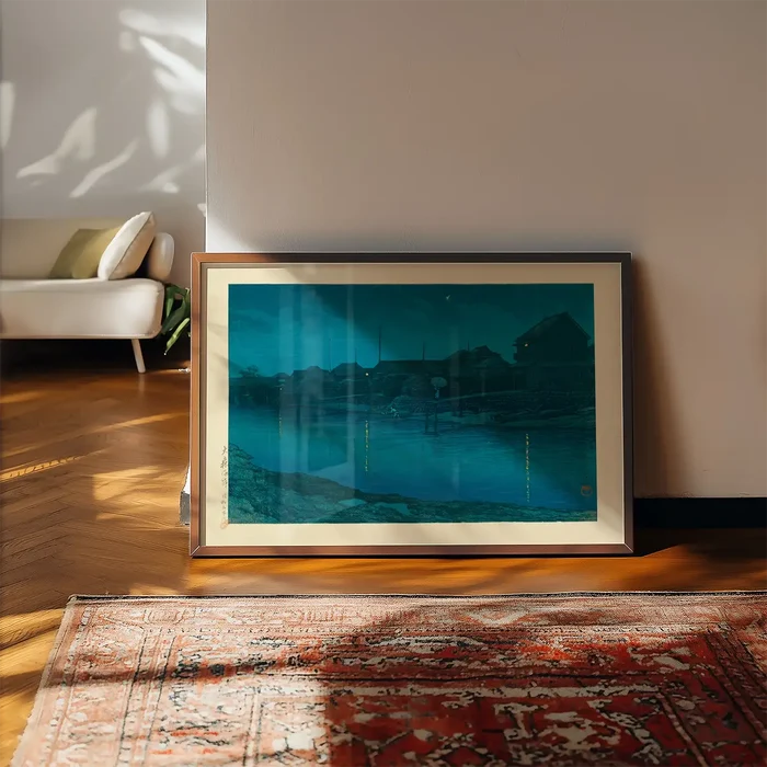 Omori Coast by Hasui Kawase print framed, leaning on a wooden floor beside a rug