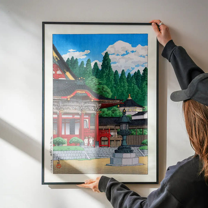 Red Temple by Hasui Kawase print being hung on a wall in a black frame