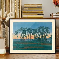 Setting Sun by Hasui Kawase print framed on a living room bookshelf